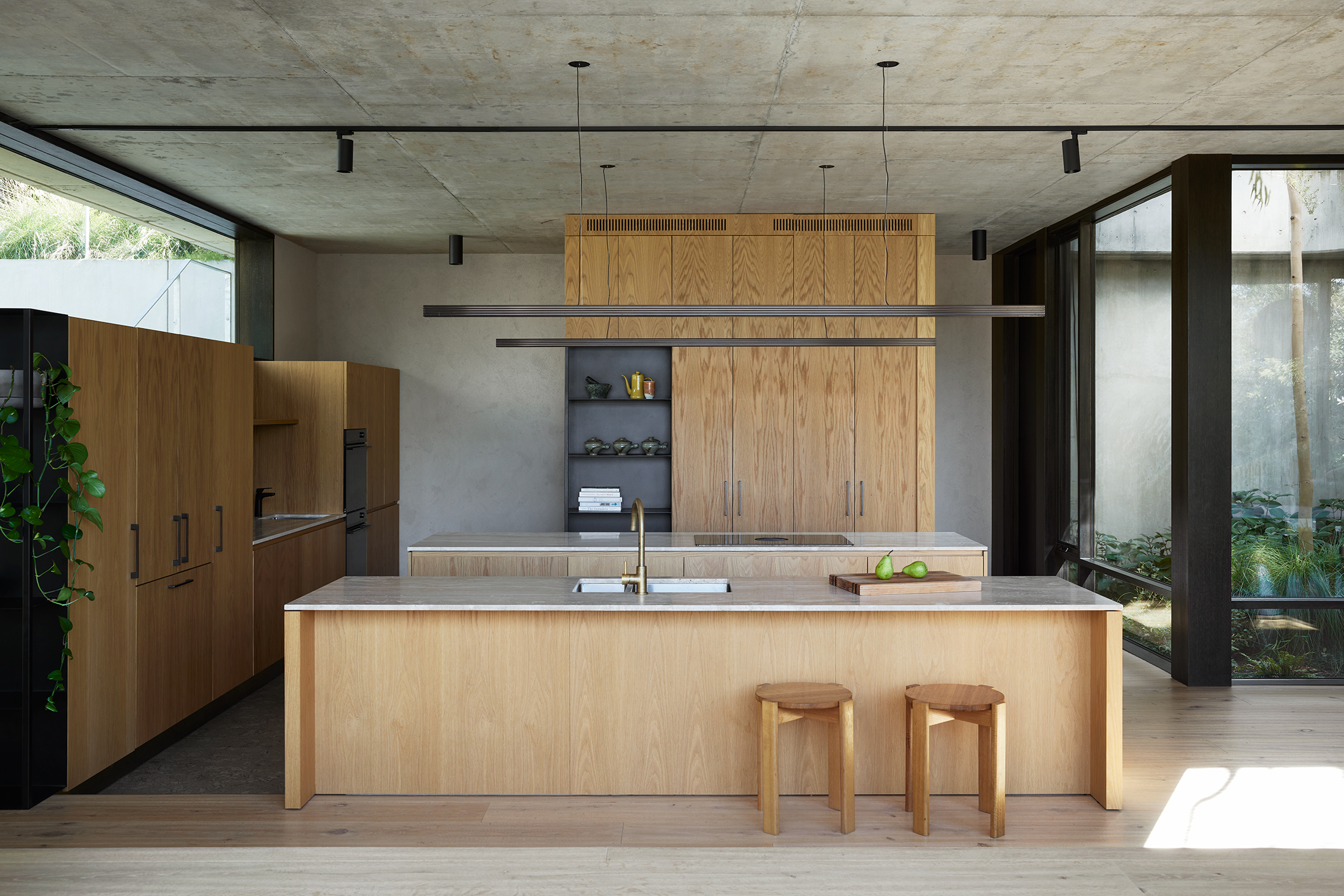 The Boulevard by Archier kitchen with linear pendant, brass mixer, timber joinery, and island stools