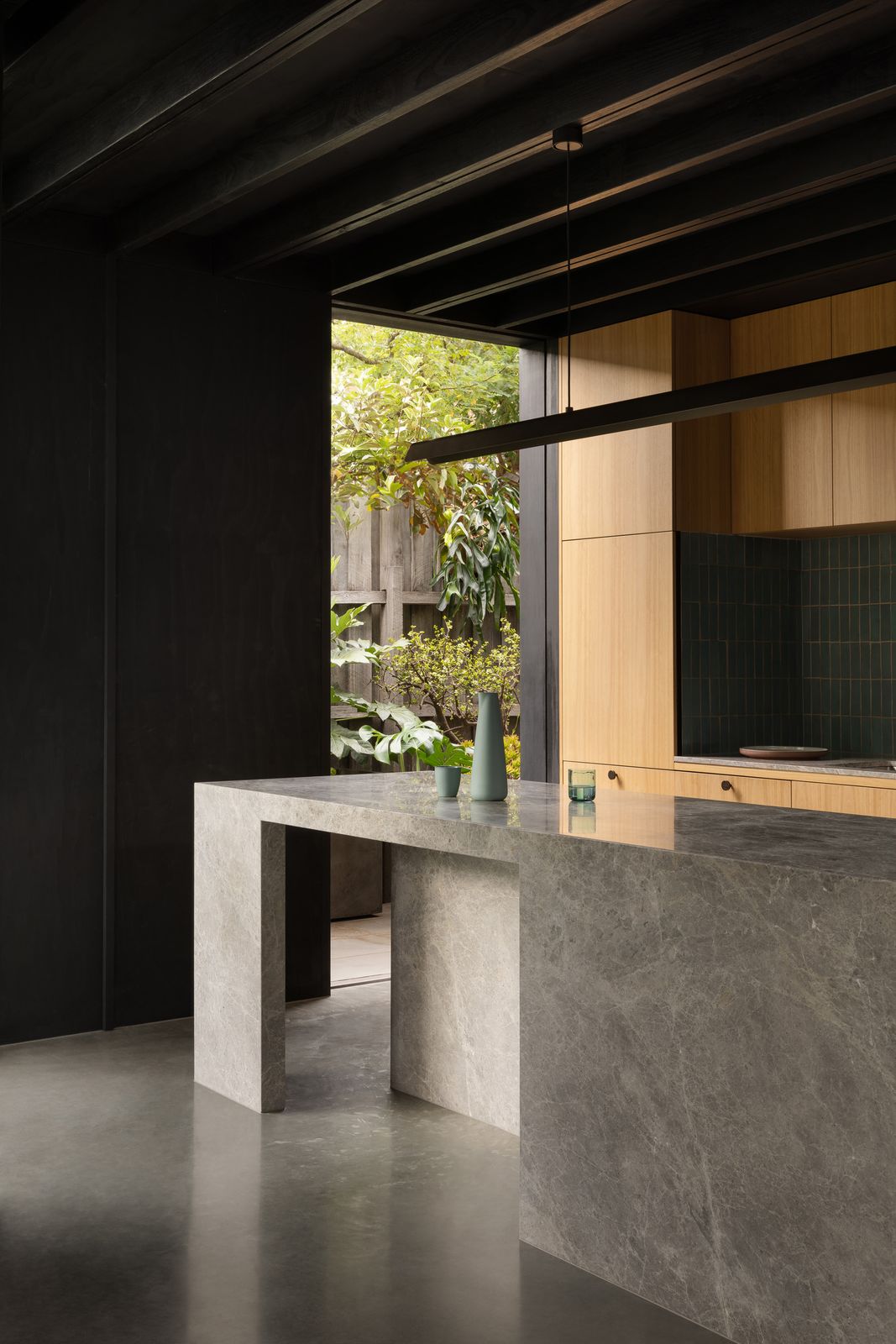 Borrowed Garden House kitchen with stone island, timber joinery, tiled splashback, and linear pendant light