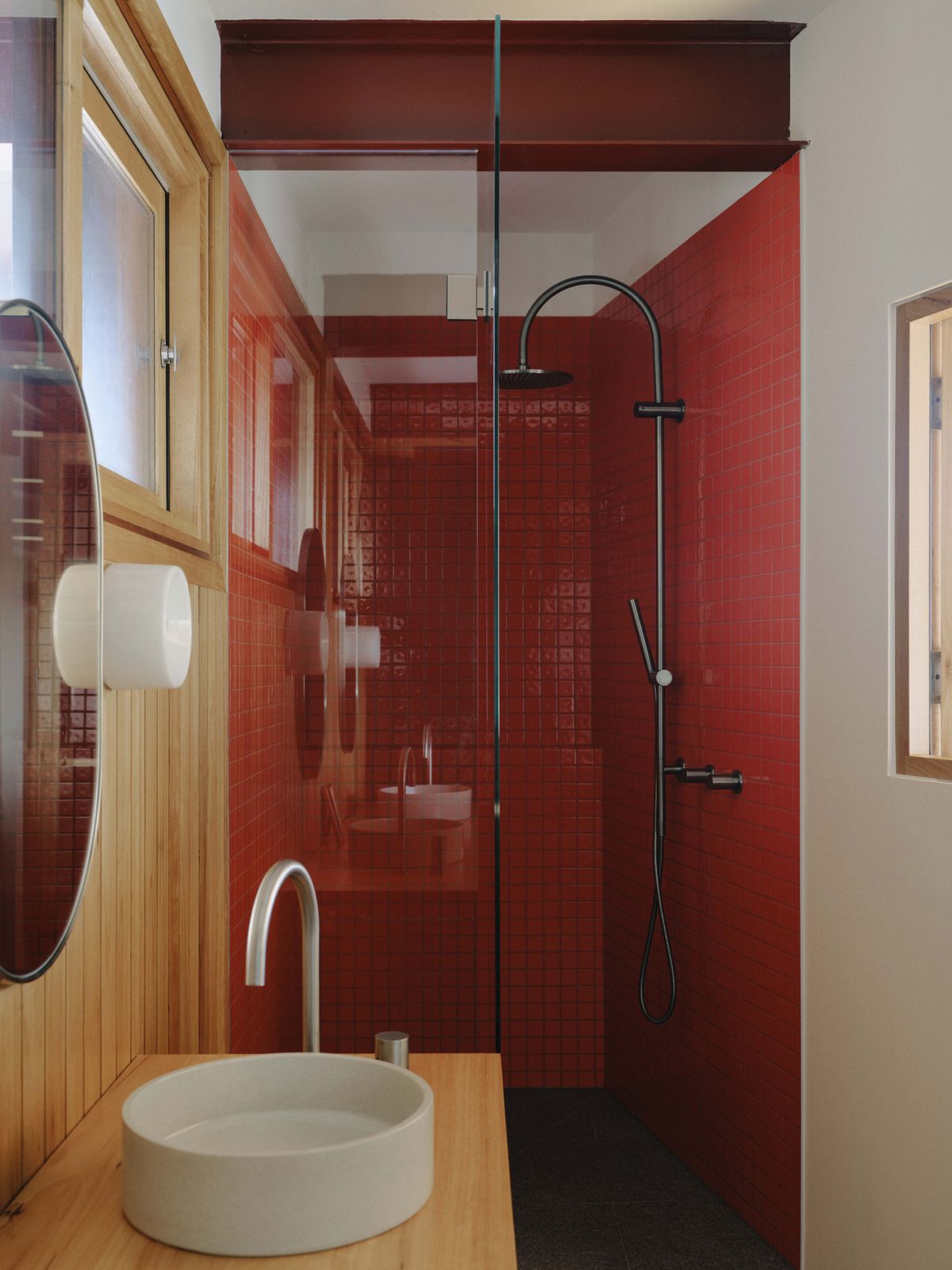 Merri Creek House bathroom with red mosaic tiles, shower tapware, and basin
