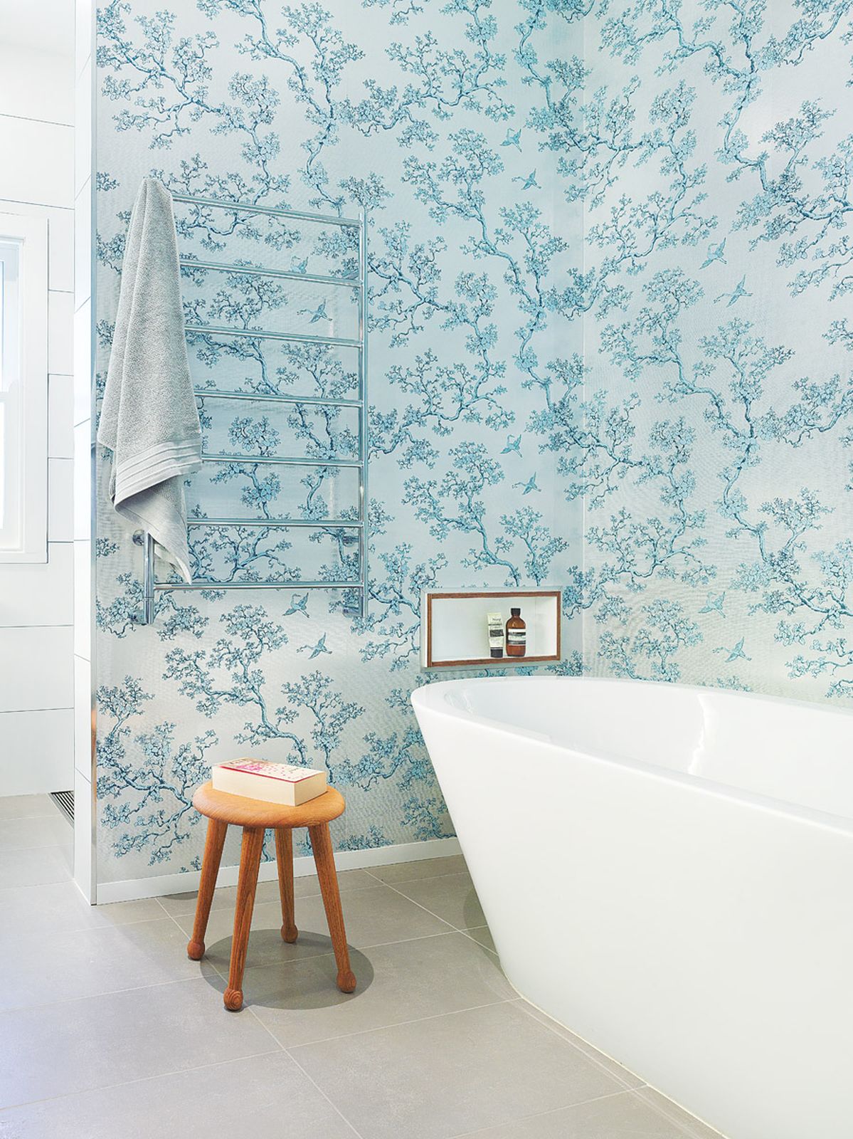Preston Residence bathroom with bath, towel rail, patterned wall covering, and floor tiles
